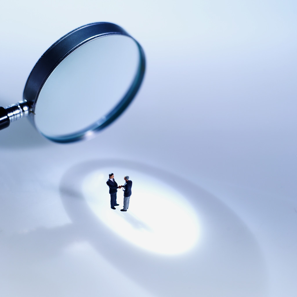 Close-up of magnifying glass focusing on two people